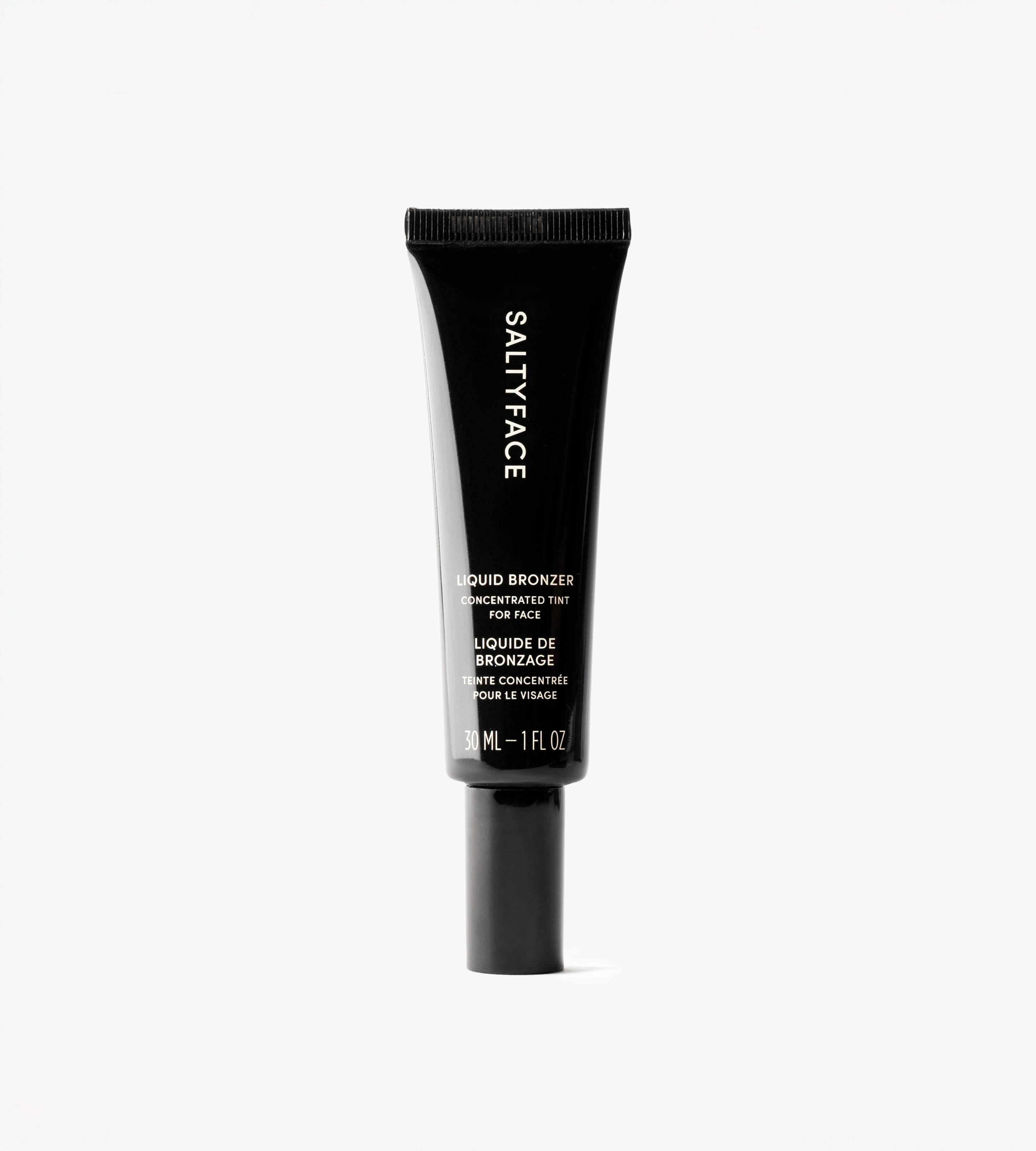 A black tube of Liquid Bronzer v2, 30 mL (1 fl oz), with hyaluronic acid is shown standing upright against a plain white background.